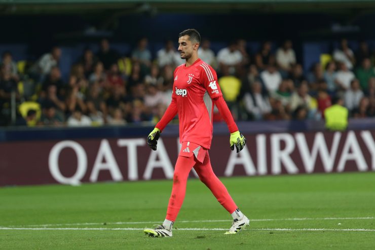Mattia Perin, portiere della Juventus, cammina in campo con la divisa da portiere rosso durante una partita di Serie A 2025/26.