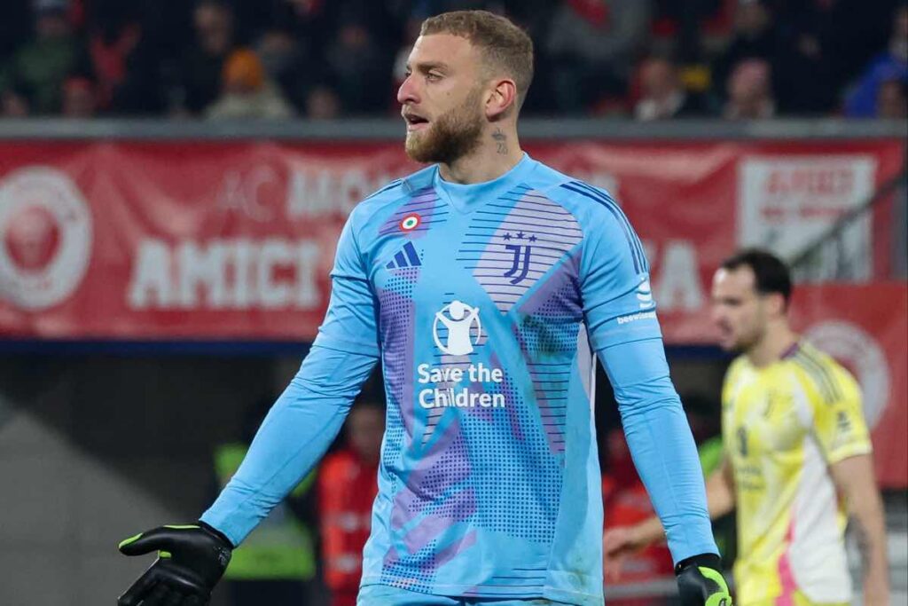 Michele Di Gregorio, portiere della Juventus, esprime frustrazione durante una partita, con il volto segnato dall’intensità del match.