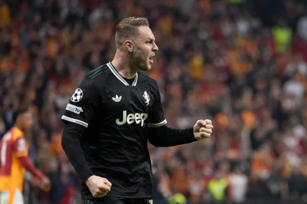 Teun Koopmeiners in azione con la maglia della Juventus nera durante una partita, con lo stadio sullo sfondo