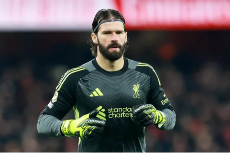 Alisson, portiere del Liverpool, con divisa nera Adidas e guantoni gialli durante una partita