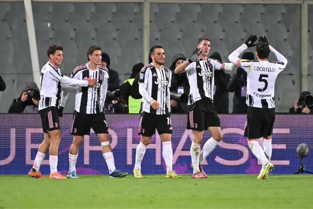 Giocatori della Juventus esultano insieme in campo dopo una rete, indossando la maglia bianconera