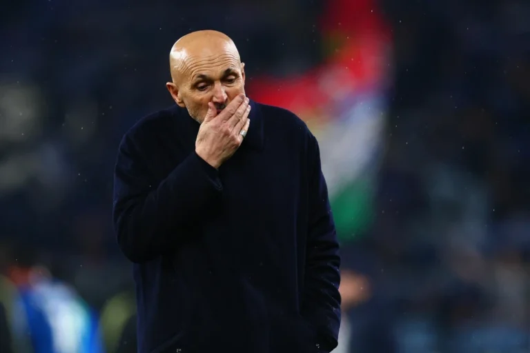 Luciano Spalletti in panchina con mano al volto, espressione concentrata durante una partita