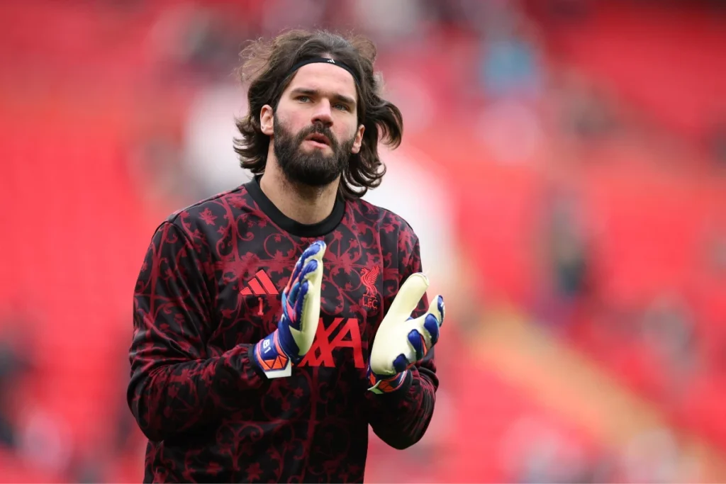 Alisson portiere durante il riscaldamento con guantoni blu e gialli