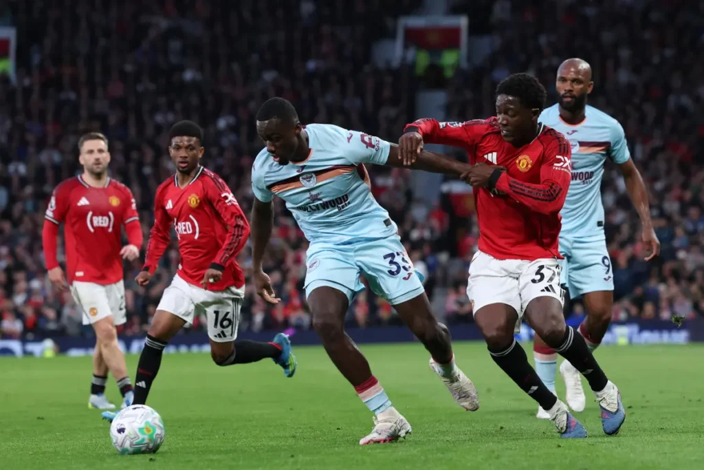 Michael Kayode in azione durante Manchester United-Brentford, contrasta un avversario in maglia celeste