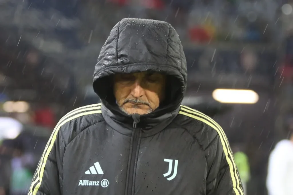 Luciano Spalletti in panchina con la tuta Juventus sotto la pioggia durante una partita