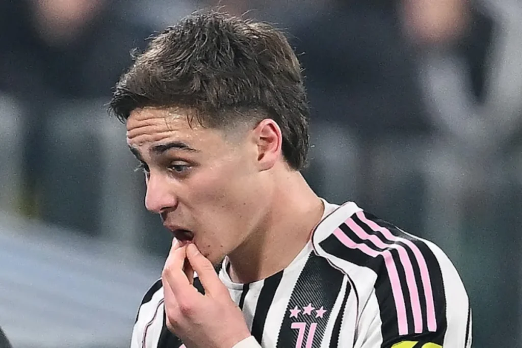 Kenan Yildiz della Juventus in maglia bianconera con strisce rosa, concentrato durante la partita