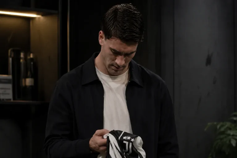 Dusan Vlahovic osserva la maglia della Juventus con sguardo concentrato
