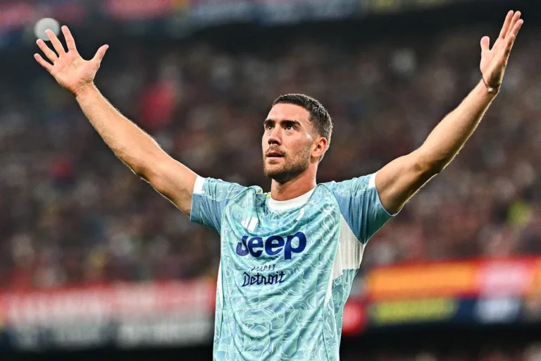 Dusan Vlahovic esulta con le braccia alzate indossando la maglia della Juventus in campo