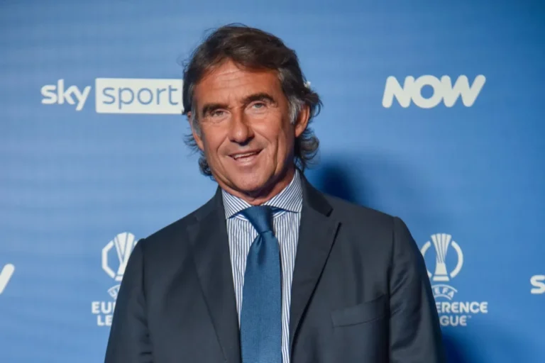 Giovanni Carnevali in abito nero e cravatta blu davanti al backdrop Sky Sport e NOW durante evento ufficiale