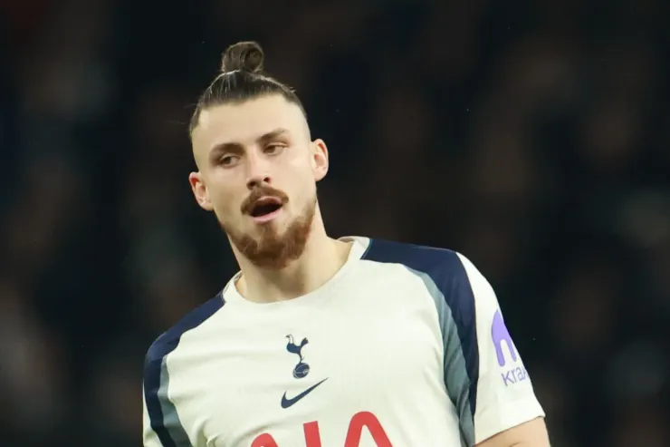 Dragusin durante una partita, indossa la maglia del Tottenham con il logo della squadra