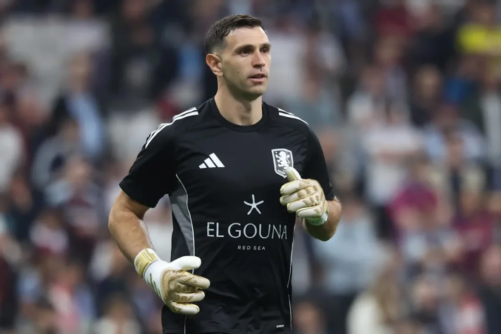 Emiliano Martinez, portiere dell'Aston Villa, durante una partita in maglia nera con guanti da portiere