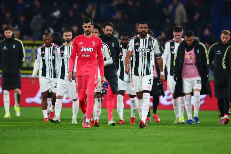 Squadra Juventus cammina dal campo dopo una partita, portiere in divisa rossa e difensore numero 3 in maglia bianconera con staff al seguito