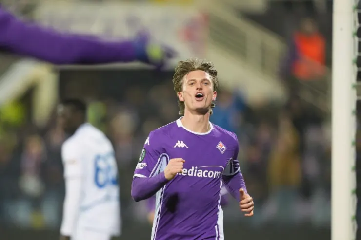 Gudmundsson in maglia Fiorentina durante una partita, con lo sguardo rivolto verso l'alto