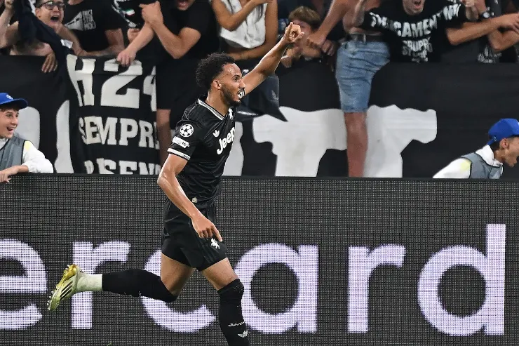 Giocatore della Juventus esulta davanti ai tifosi durante una partita, indossando la maglia bianconera