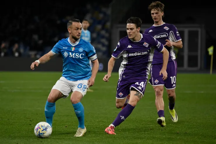 Lobotka in azione con il pallone durante Napoli-Fiorentina, pressato da giocatori avversari in maglia viola