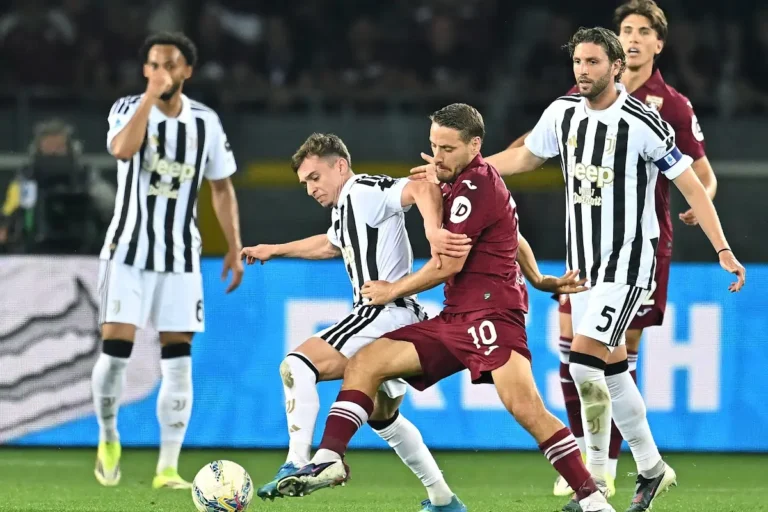 Contrasto di gioco tra un giocatore della Juventus e un avversario del Torino durante il derby, con palla in movimento