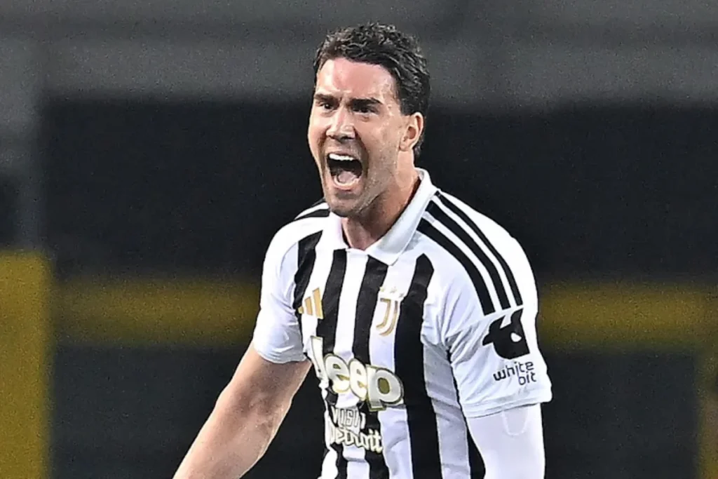 Dusan Vlahovic esulta durante una partita della Juventus con la maglia bianconera Adidas