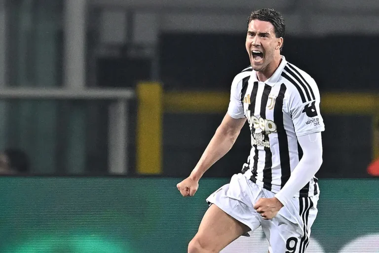 Vlahovic esulta durante una partita con la maglia della Juventus a strisce bianche e nere