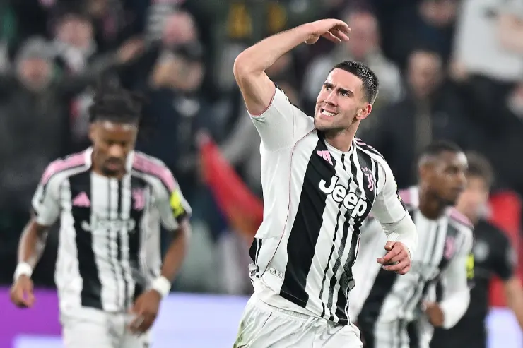 Dusan Vlahovic con la maglia della Juventus durante una partita, esulta con il braccio alzato