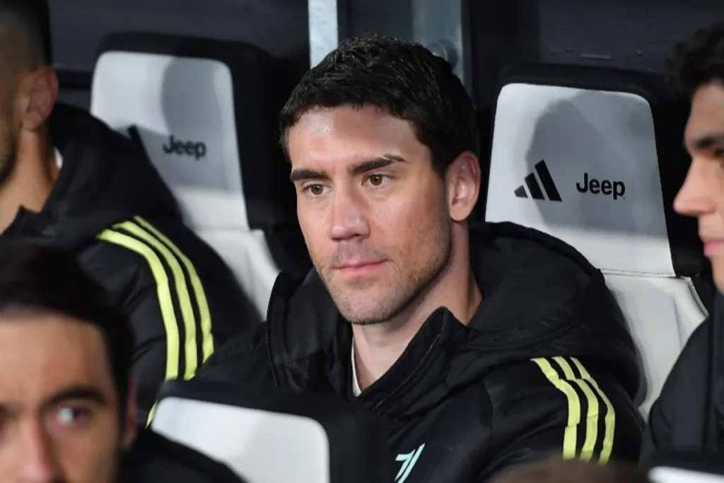 Dusan Vlahovic in panchina con la tuta Juventus Adidas nera e strisce gialle, durante una partita