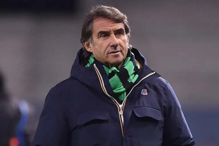 Giovanni Carnevali in giacca blu e sciarpa verde durante un evento calcistico