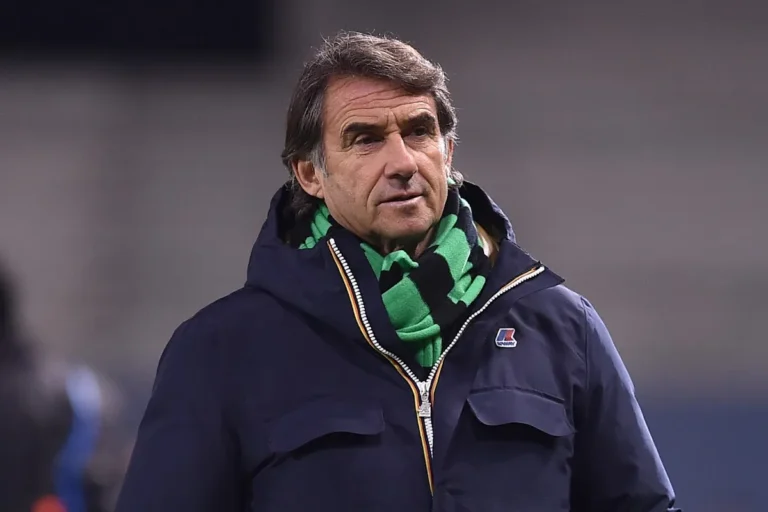 Giovanni Carnevali, dirigente, osserva dal bordo campo indossando una giacca blu navy e sciarpa verde
