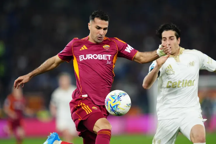 Celik in azione con la maglia della Roma durante una partita di calcio, mentre contrasta un avversario