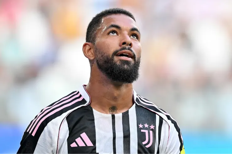Douglas Luiz in maglia Juventus durante una partita, con lo sguardo rivolto verso l'alto