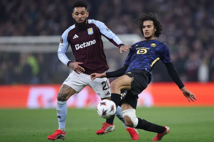Douglas Luiz in azione durante una partita: il centrocampista con maglia Aston Villa contrasta un avversario in maglia blu