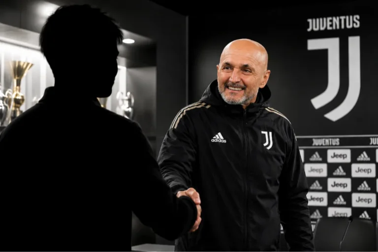 Allenatore Juventus in tuta Adidas stringe la mano durante incontro nello spogliatoio con stemma Juventus sullo sfondo