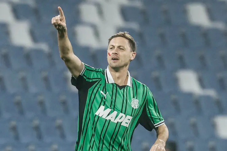 Nemanja Matic in maglia verde con sponsor Mapei durante una partita, con braccio alzato