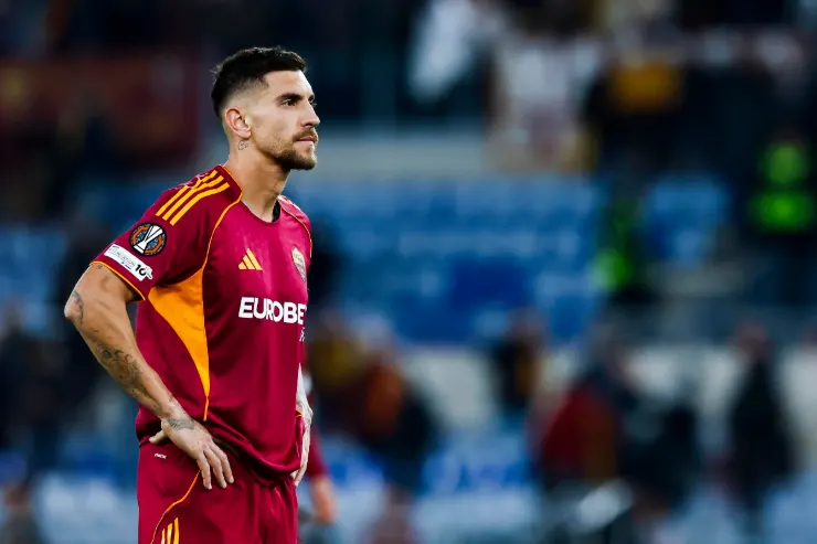 Lorenzo Pellegrini in maglia Roma rossa durante una partita, in campo con lo sguardo concentrato