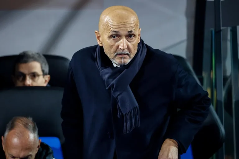 Luciano Spalletti in panchina durante una partita, indossa giacca blu scuro e sciarpa