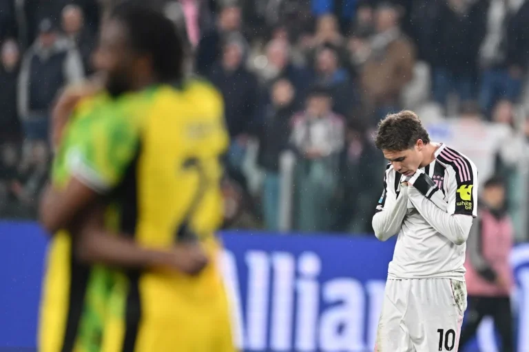 Kenan Yildiz con maglia numero 10 della Juventus, sguardo deluso durante la partita sotto la pioggia