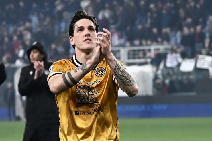 Zaniolo in maglia gialla dell'Udinese durante una partita, esulta verso il pubblico dello stadio