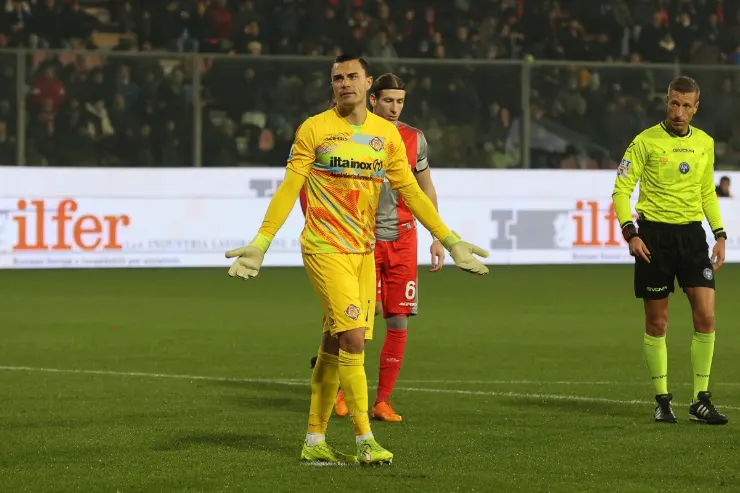 Audero portiere in maglia gialla durante una partita di calcio, con arbitro e altri giocatori in campo