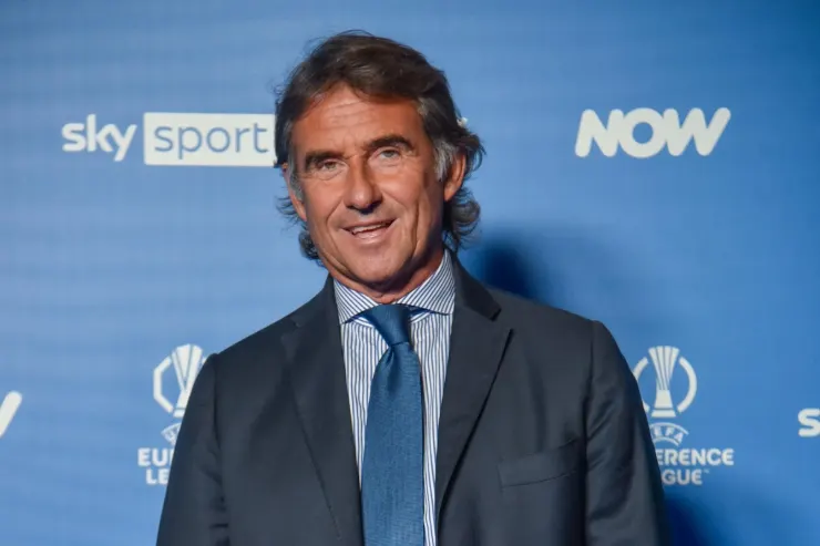 Uomo in giacca blu e camicia a righe durante un evento Sky Sport