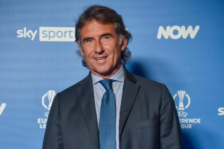 Carnevali in abito blu e camicia a righe durante un evento Sky Sport con loghi UEFA Europa League sullo sfondo