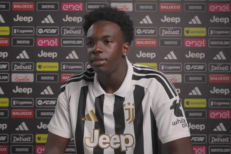 Giocatore della Juventus in maglia bianconera durante un'intervista con lo sfondo dello studio televisivo