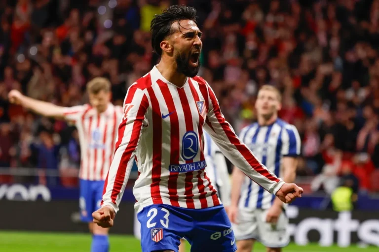 Nico González esulta durante una partita dell'Atlético Madrid, numero 23, in maglia rosso-bianca davanti al pubblico dello stadio