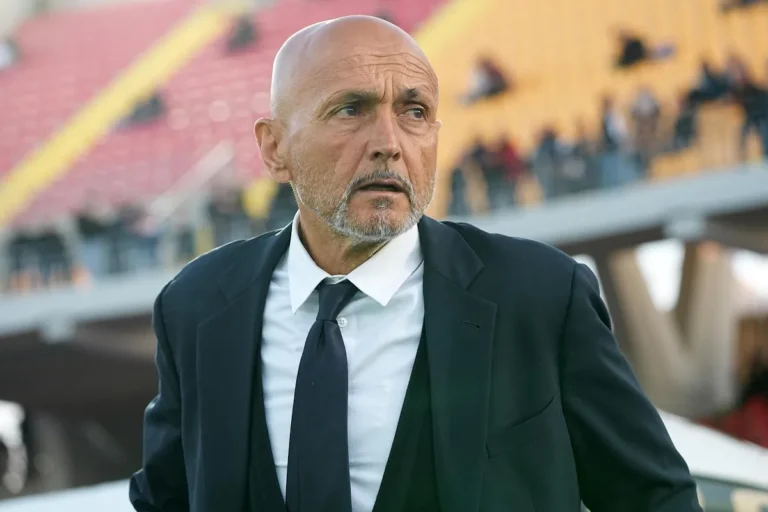 Luciano Spalletti in panchina durante una partita, indossa completo scuro e cravatta