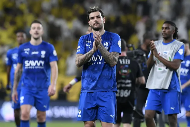 Theo Hernández in maglia blu durante una partita, con le mani unite al petto