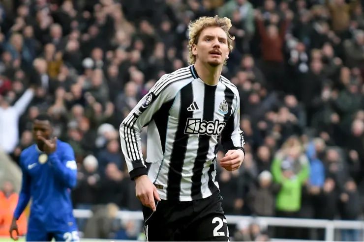 Woltemade in maglia Newcastle durante una partita, centrocampista con pallone a centrocampo