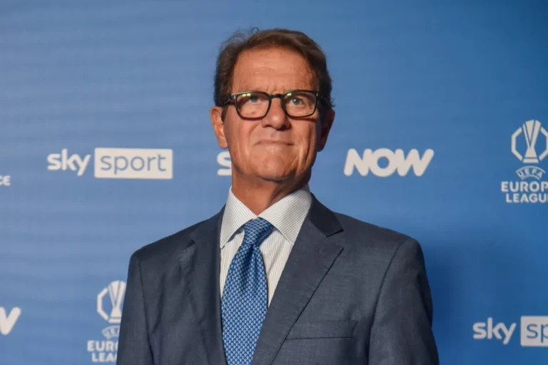 Fabio Capello in abito scuro e cravatta blu davanti al backdrop Sky Sport e UEFA Europa League