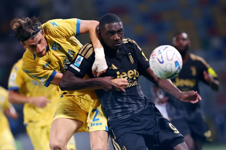 Kolo Muani in azione durante una partita di calcio, contrasta un avversario in maglia gialla