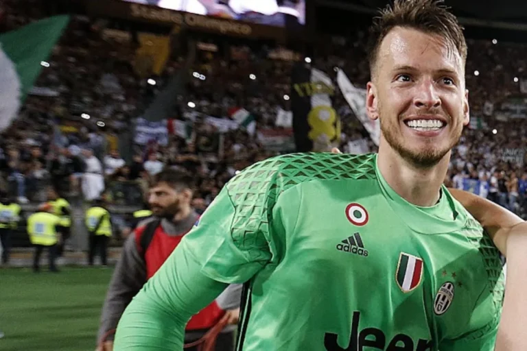 Portiere con maglia verde Juventus sorride durante una partita allo stadio