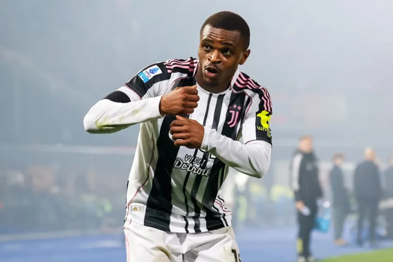 Pierre Kalulu in maglia Juventus durante una partita, con le braccia tese verso il basso in gesto di concentrazione