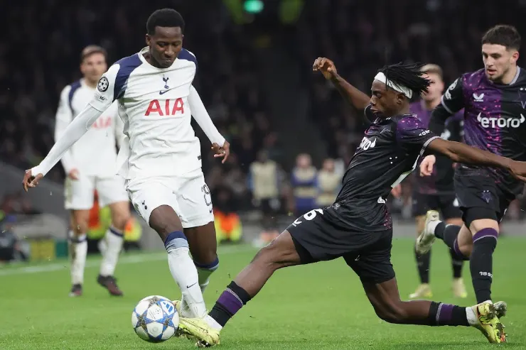 Pape Sarr in azione con la maglia del Tottenham contro un difensore in divisa scura durante una partita di calcio