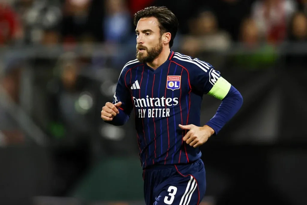 Tagliafico in maglia Olympique Lione con fascia da capitano, durante una partita in campo