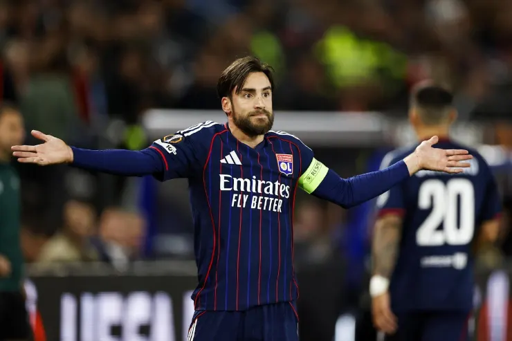Tagliafico con fascia da capitano durante una partita, indossa la maglia blu e rossa dell'Olympique Lione con sponsor Emirates